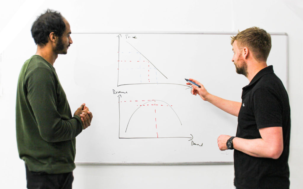 two people showing graphs on a whiteboard